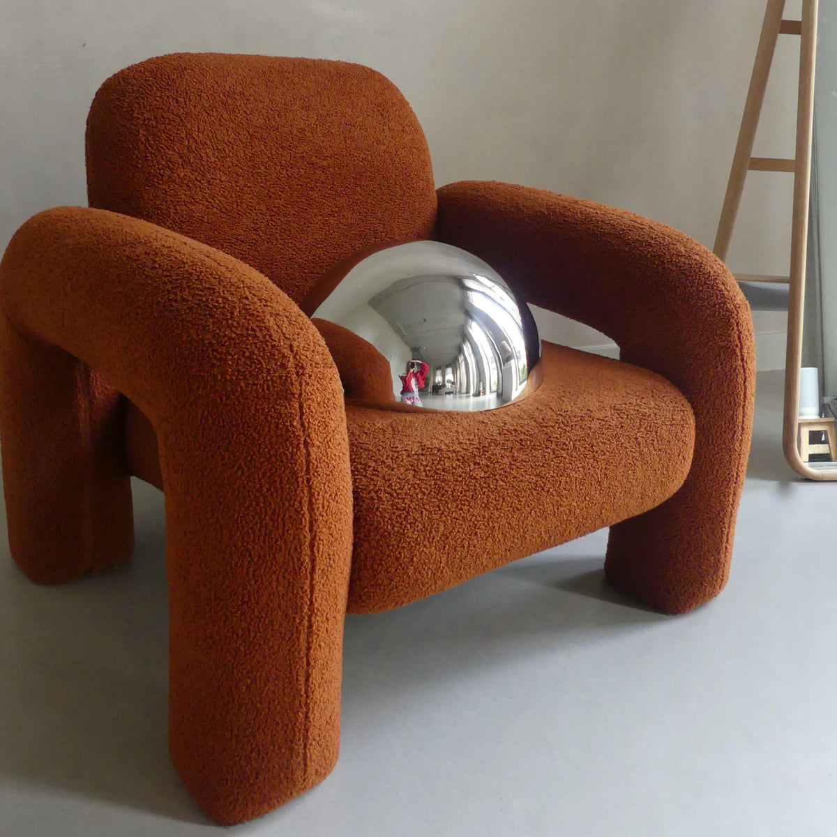 The Lumevre convex mirror 35 cm resting on a chair seat to show its size