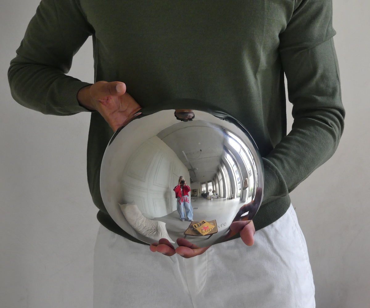A person holding the Lumevre convex mirror 25 cm