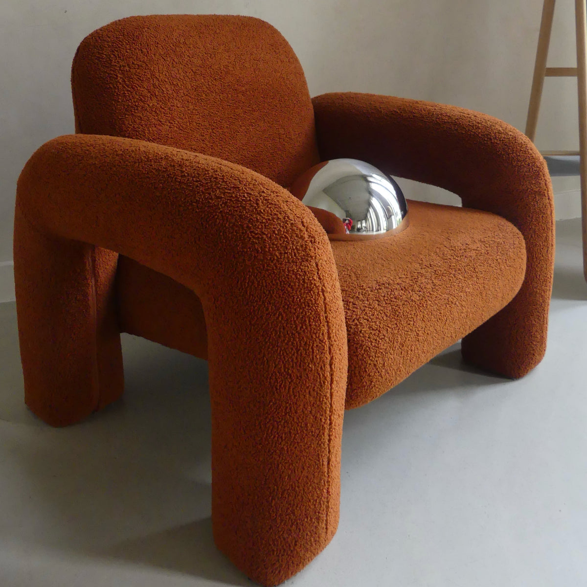 A Lumevre convex mirror 25 cm resting on a chair seat to show its size